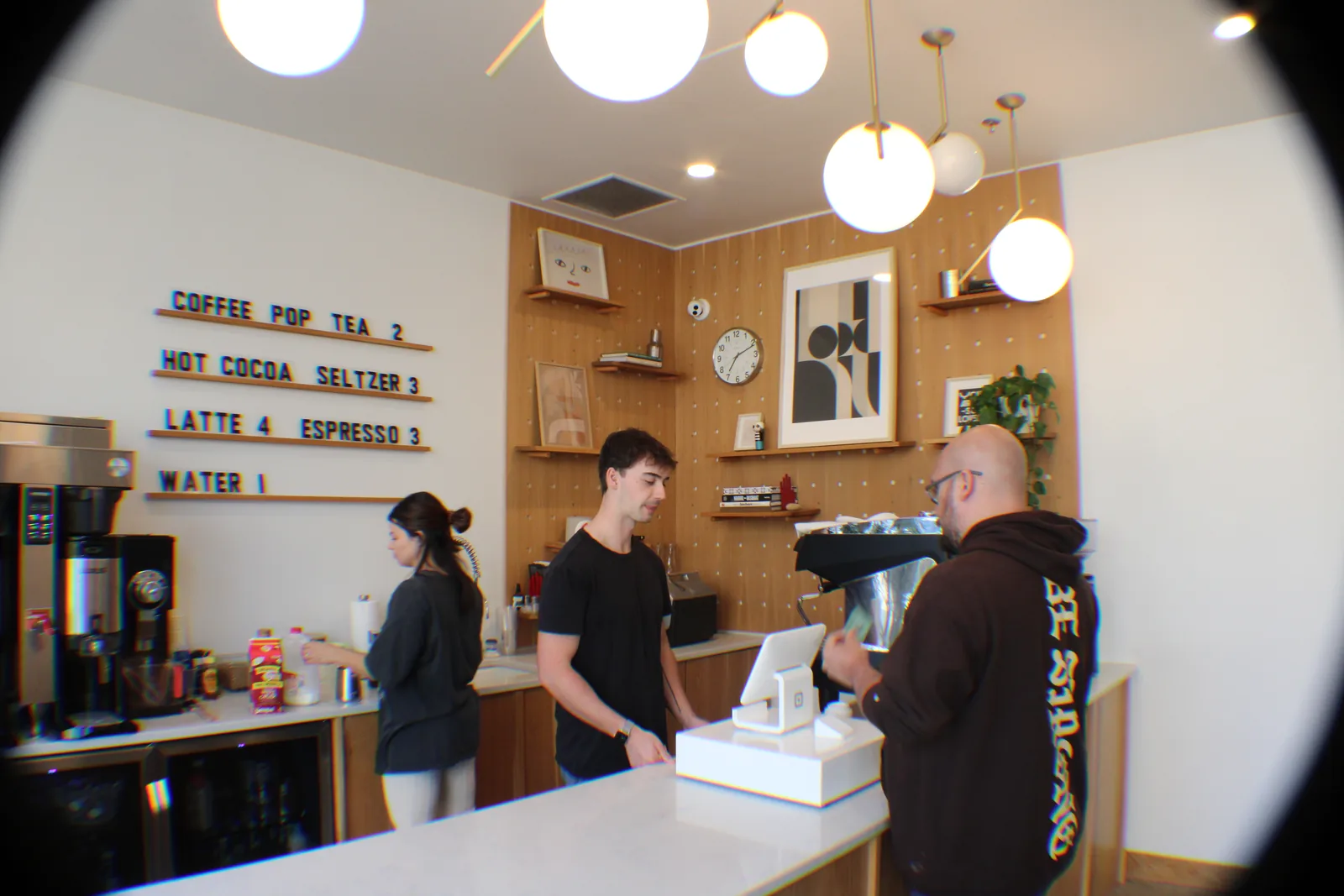 People serve at a coffee counter before a gathering.